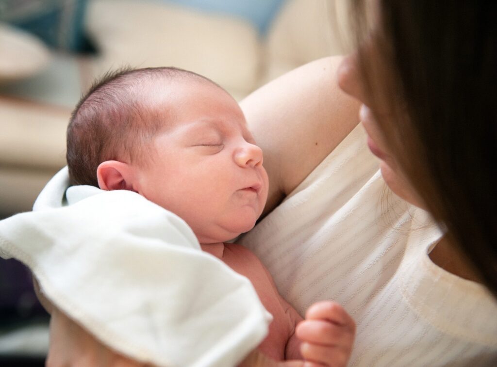 New mother cradling her sleeping baby